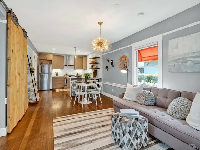 a kitchen with stainless steel appliances a dining table chairs and refrigerator