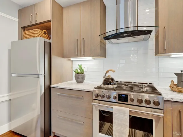 a kitchen with granite countertop white cabinets and a window