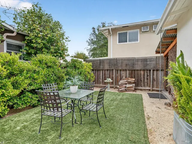 a view of a backyard with table and chairs and iron fence