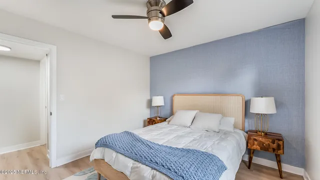 a bedroom with a bed and a lamp on the dresser