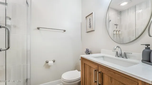 a bathroom with a sink a toilet and a mirror