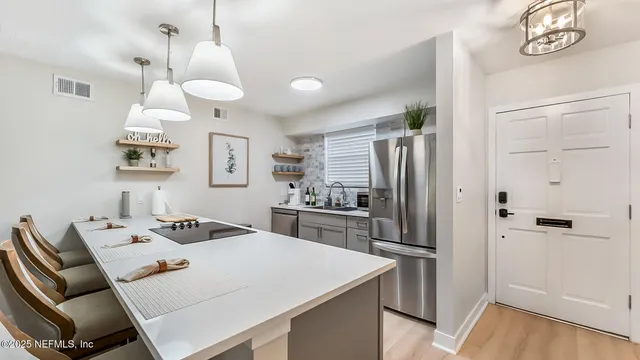 a kitchen with a refrigerator a stove a sink and a dining table