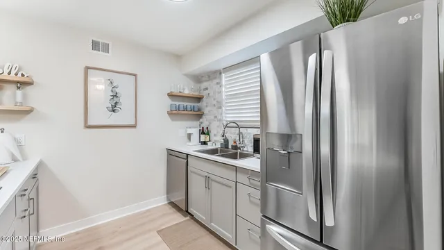 a kitchen with stainless steel appliances granite countertop a refrigerator and a sink