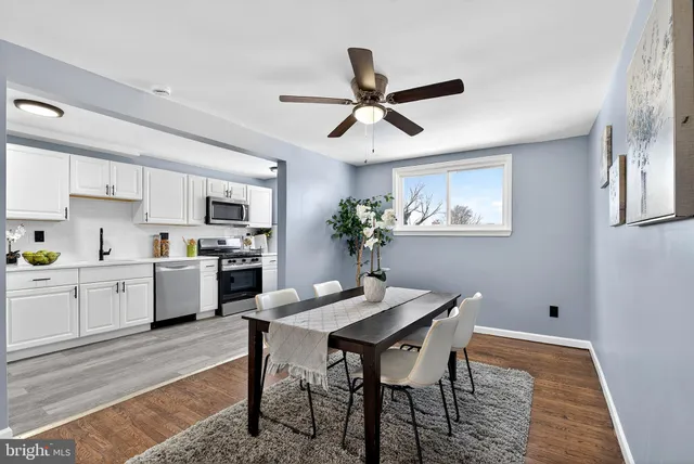 a kitchen with a dining table chairs stainless steel appliances and cabinets