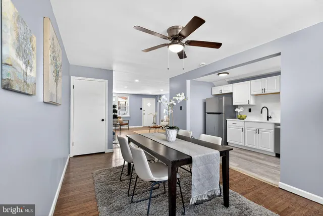 a kitchen with a dining table chairs refrigerator and cabinets