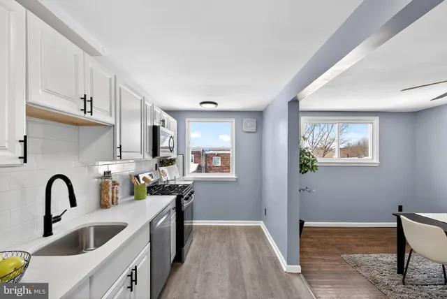 a kitchen with stainless steel appliances granite countertop a sink a stove and cabinets