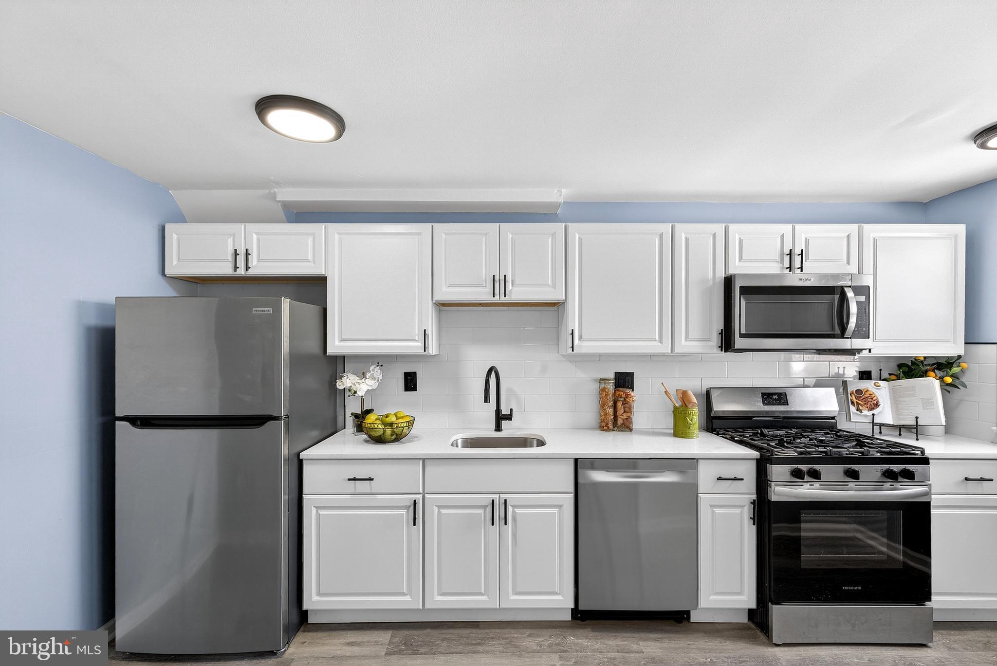 1216 Harshaw Road Brookhaven, PA 19015 - Photo 18 of 38 a kitchen with a refrigerator sink and white cabinets