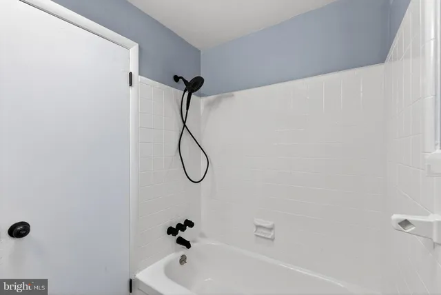 a bathroom with a bath tub with a shower