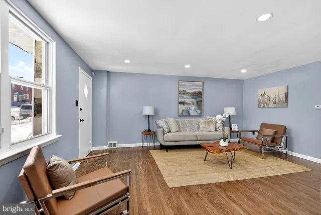 a living room with furniture and a wooden floor