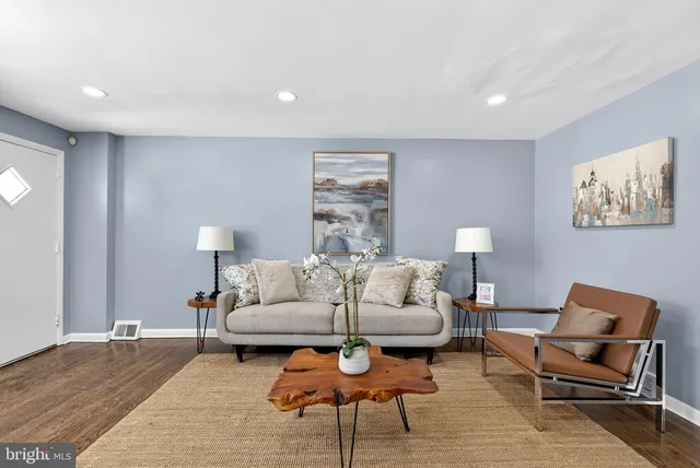 a living room with furniture a lamp and a rug