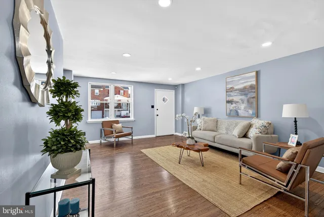 a living room with furniture potted plant and a mirror