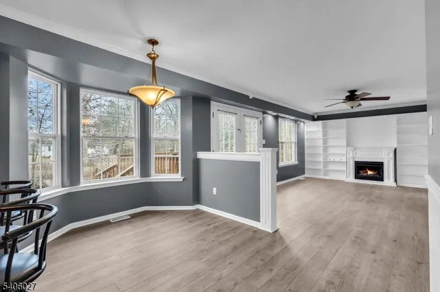 a view of an empty room with window and fire place