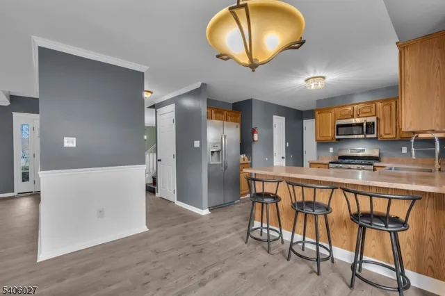 a view of kitchen with stainless steel appliances granite countertop dining room cabinets and wooden floor