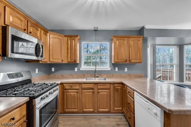 a kitchen with stainless steel appliances granite countertop a sink stove and cabinets