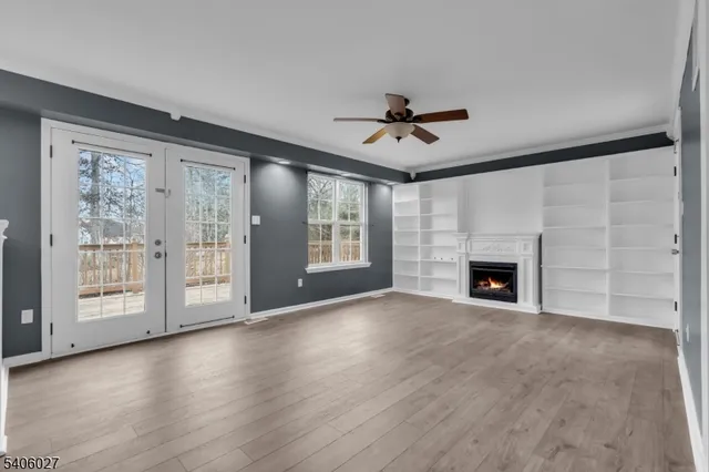 a view of an empty room with a fireplace and a window