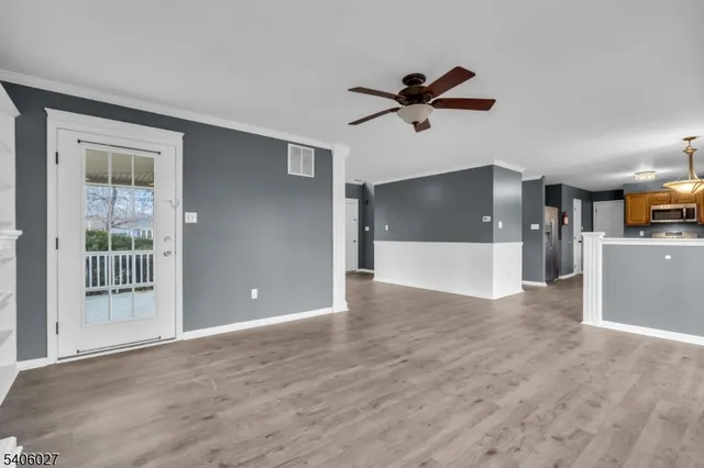a view of a livingroom with a ceiling fan and window