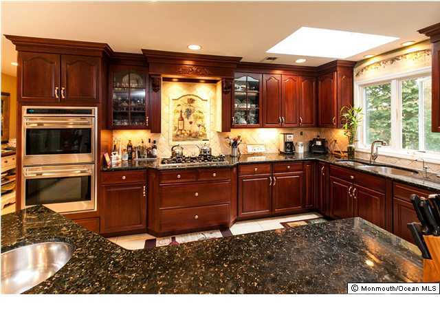 78 Knob Hill Road Morganville, NJ 07751 - Photo 3 of 3 a kitchen with a sink and wooden cabinets