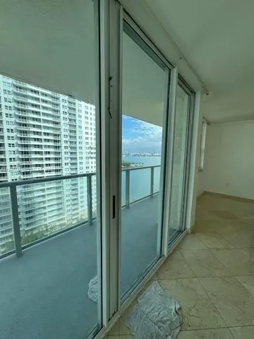 a kitchen with granite countertop a refrigerator a sink and white cabinets