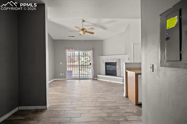 a view of an empty room with a fireplace and a window