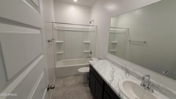 a bathroom with a granite countertop sink a toilet and shower