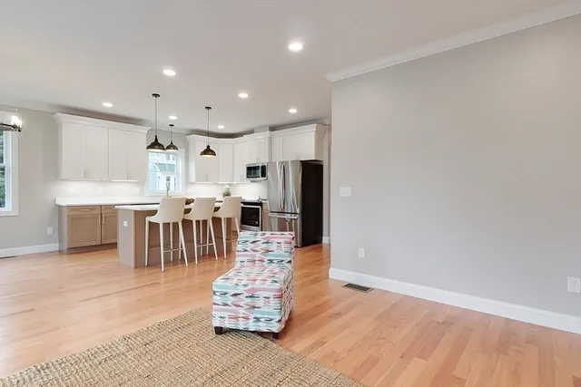 a dining hall with stainless steel appliances kitchen island granite countertop a refrigerator oven a s sink and a stove