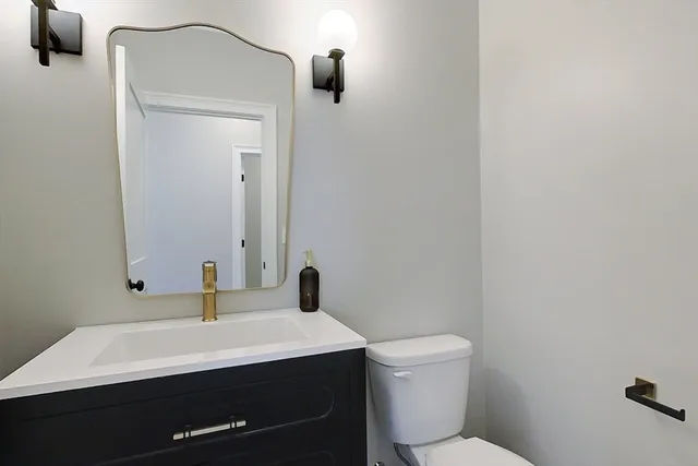 a bathroom with a sink a toilet and mirror