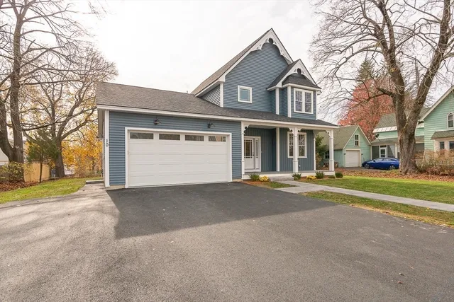 a front view of a house with a garden and trees