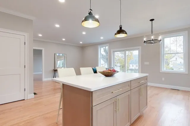 a kitchen with a sink chandelier and wooden floor