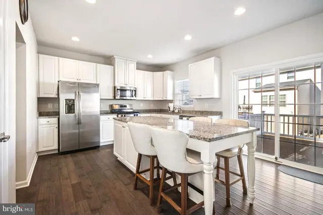 a living room with furniture kitchen view and a flat screen tv
