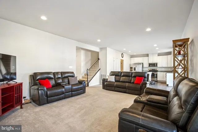 a living room with furniture a chandelier and a dining table