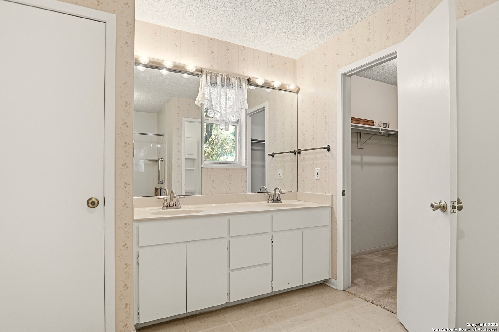 261 Fawn Lane Spring Branch, TX 78070 - Photo 12 of 36 a bathroom with a double vanity sink a mirror and a shower