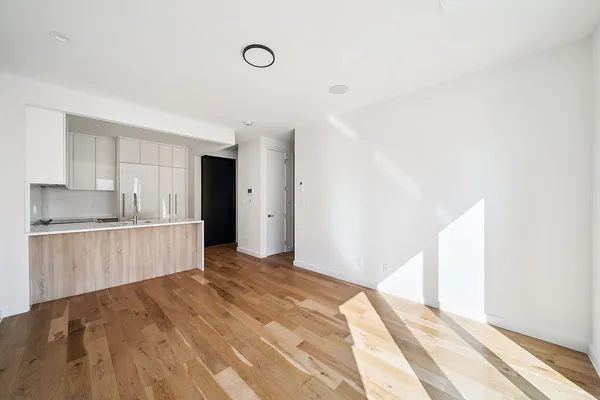 a view of kitchen with refrigerator cabinets and wooden floor