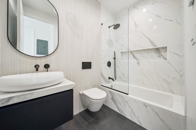 12 Broome Street, Unit 3B Brooklyn, NY 11222 - Photo 9 of 14 a bathroom with a sink a toilet and a mirror