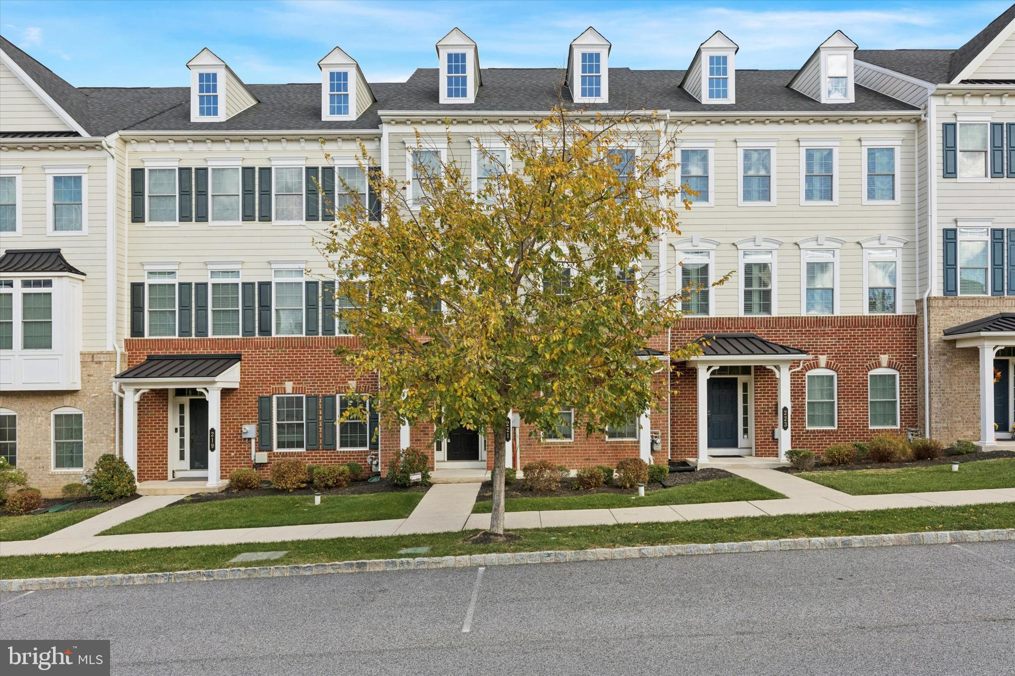 a front view of a residential apartment building with a yard and plants