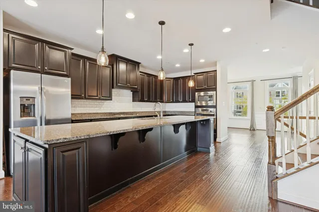 a kitchen with stainless steel appliances granite countertop a sink refrigerator and cabinets