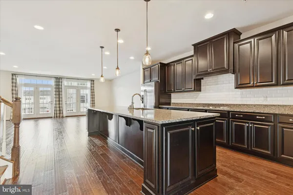 a kitchen with stainless steel appliances granite countertop a stove a sink and a wooden floors