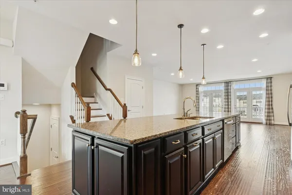 a kitchen with stainless steel appliances granite countertop a kitchen island a stove and a wooden floors