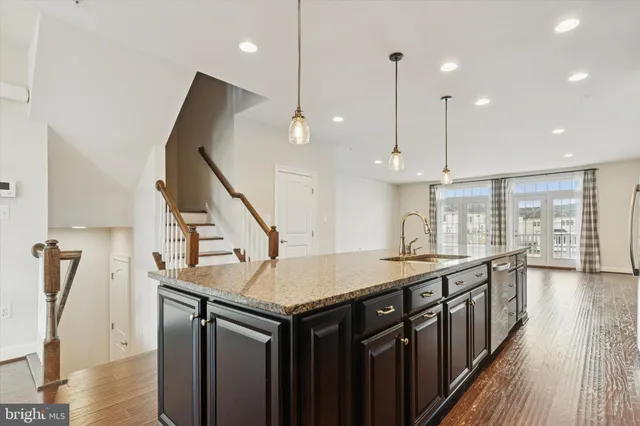 a kitchen with stainless steel appliances granite countertop a kitchen island a stove and a wooden floors