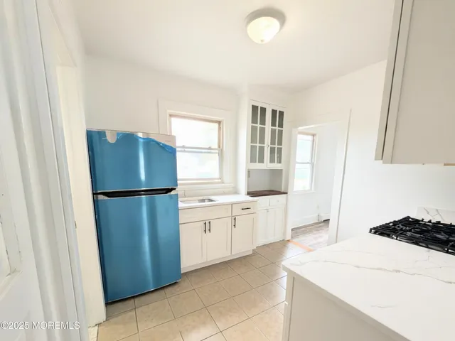 a kitchen with a refrigerator a stove top oven and cabinets