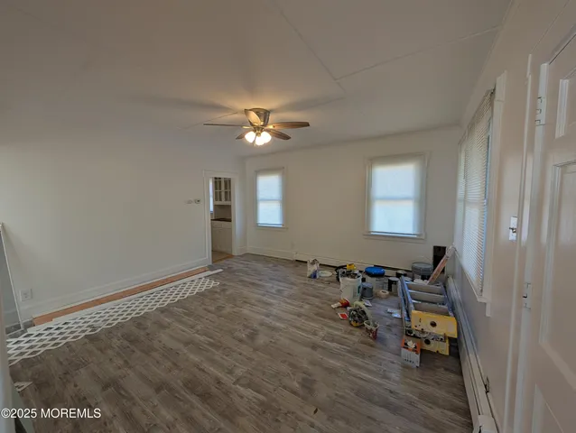 a view of a livingroom with hardwood floor and a ceiling fan