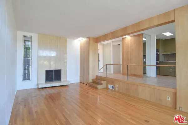 a view of a big room with wooden floor and windows