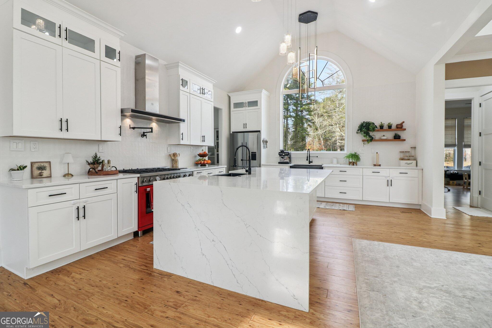 4032 Wesley Chapel Road Roswell, GA 30075 - Photo 14 of 36 a kitchen with stainless steel appliances white cabinets a stove top oven a sink and dishwasher with wooden floor