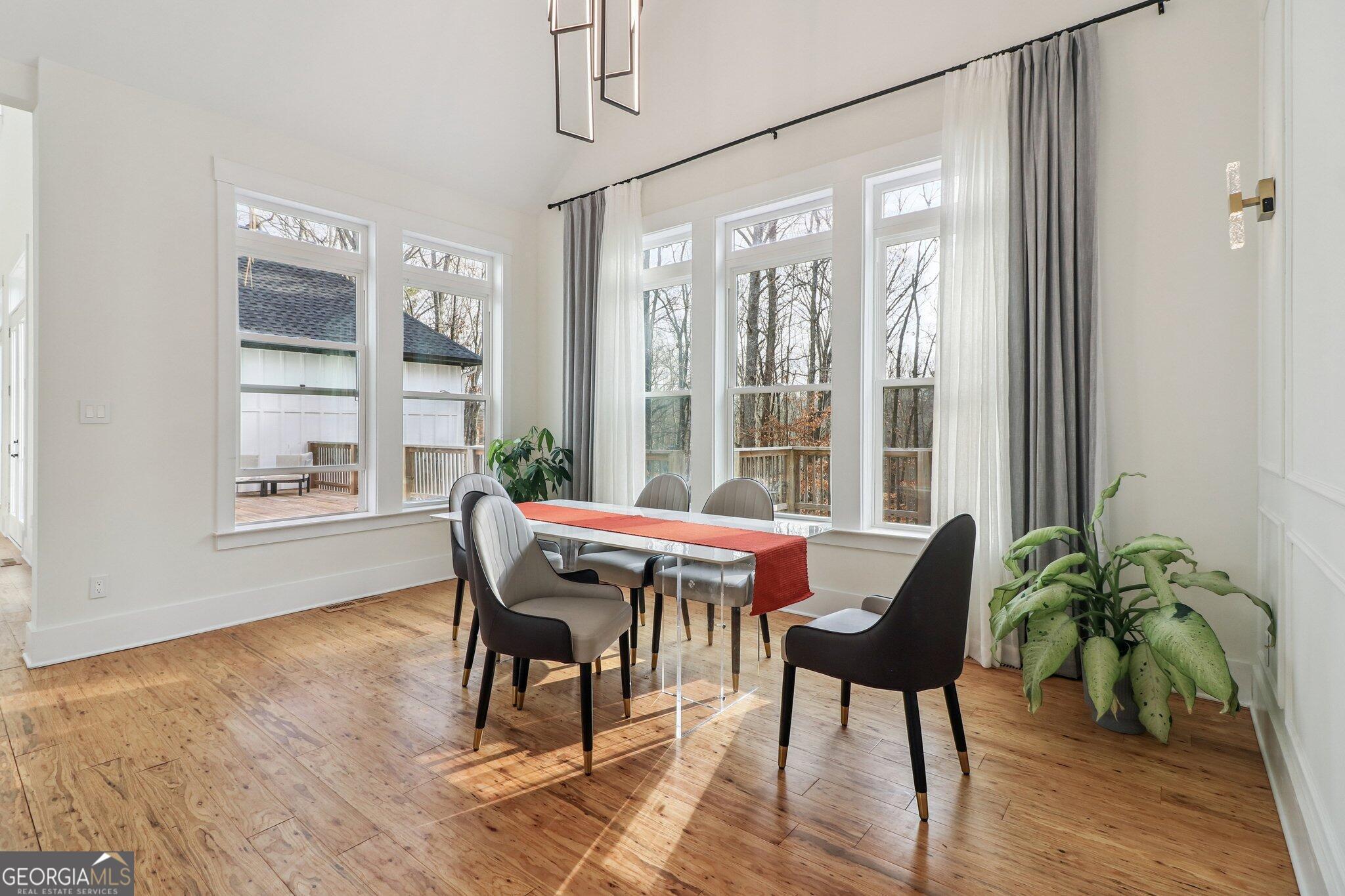 4032 Wesley Chapel Road Roswell, GA 30075 - Photo 16 of 36 a dining room with furniture potted plants and wooden floor