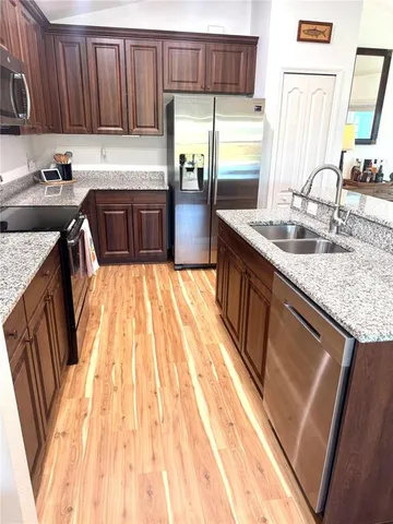 a kitchen with granite countertop wooden cabinets and stainless steel appliances