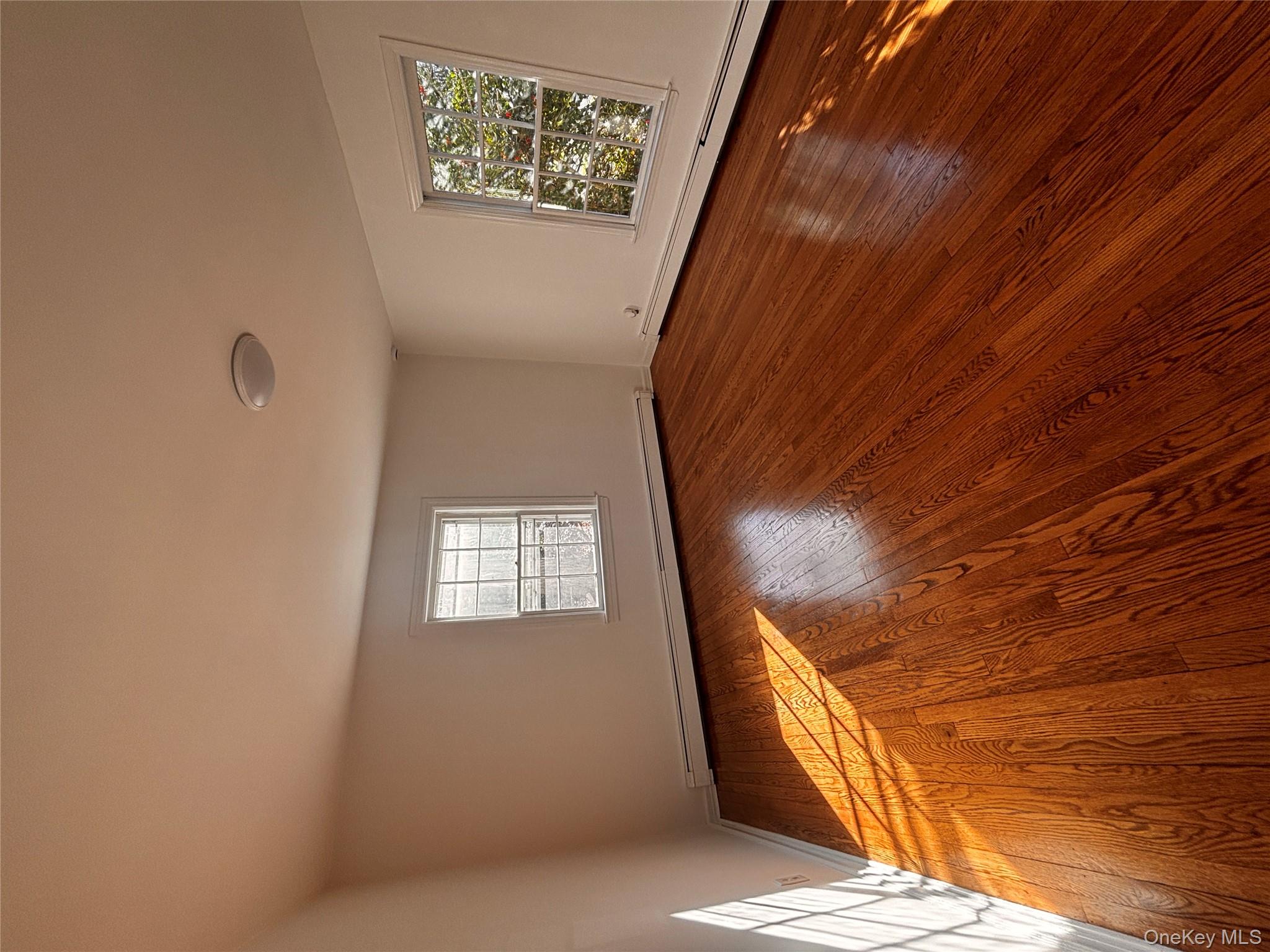 67 Turkey Lane Cold Spring Harbor, NY 11724 - Photo 11 of 18 an empty room with wooden floor and windows