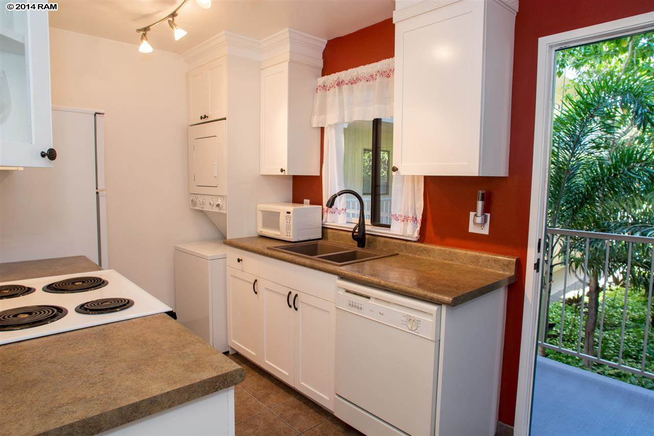 2219 South Kihei Road, Unit B214 Kihei, HI 96753 - Photo 13 of 20 a kitchen with sink a refrigerator and trees
