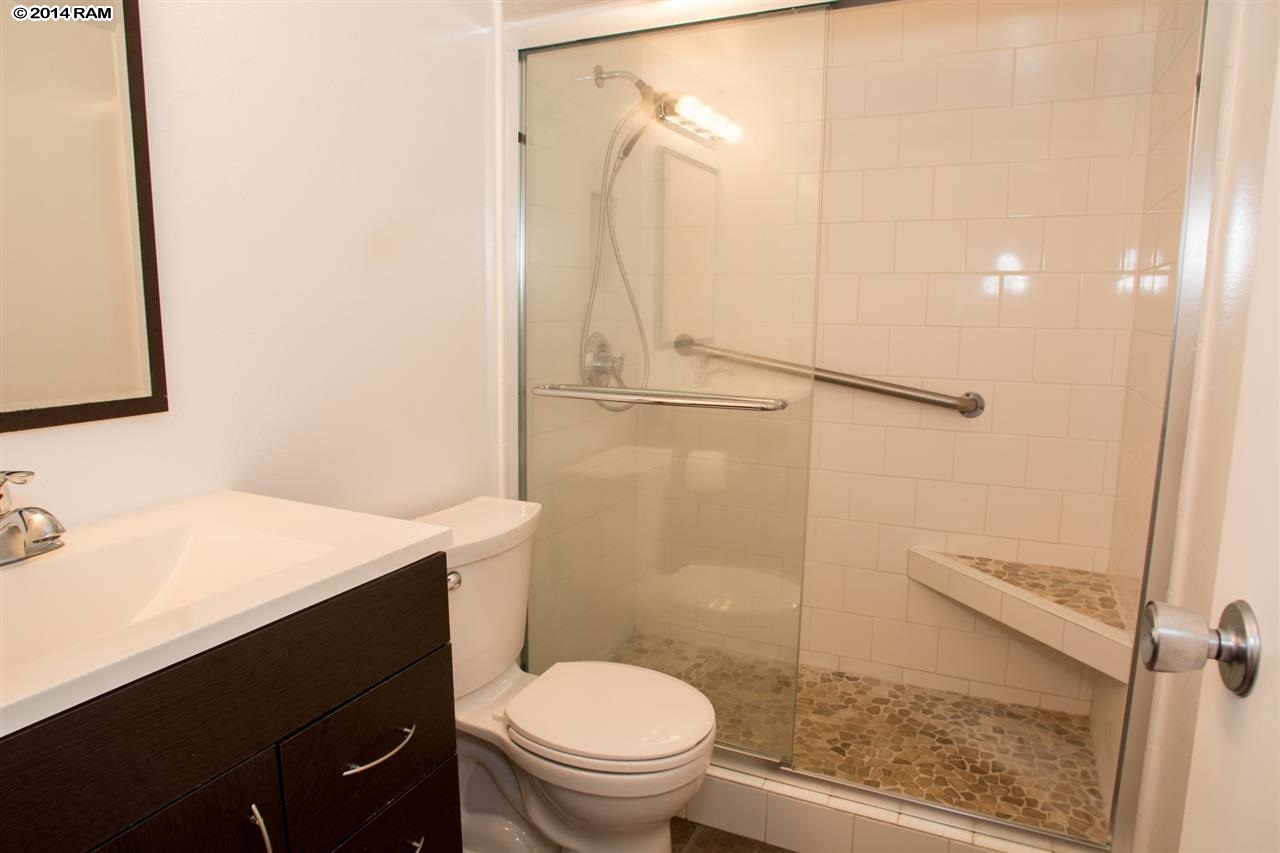 2219 South Kihei Road, Unit B214 Kihei, HI 96753 - Photo 19 of 20 a bathroom with a sink a toilet a mirror and shower