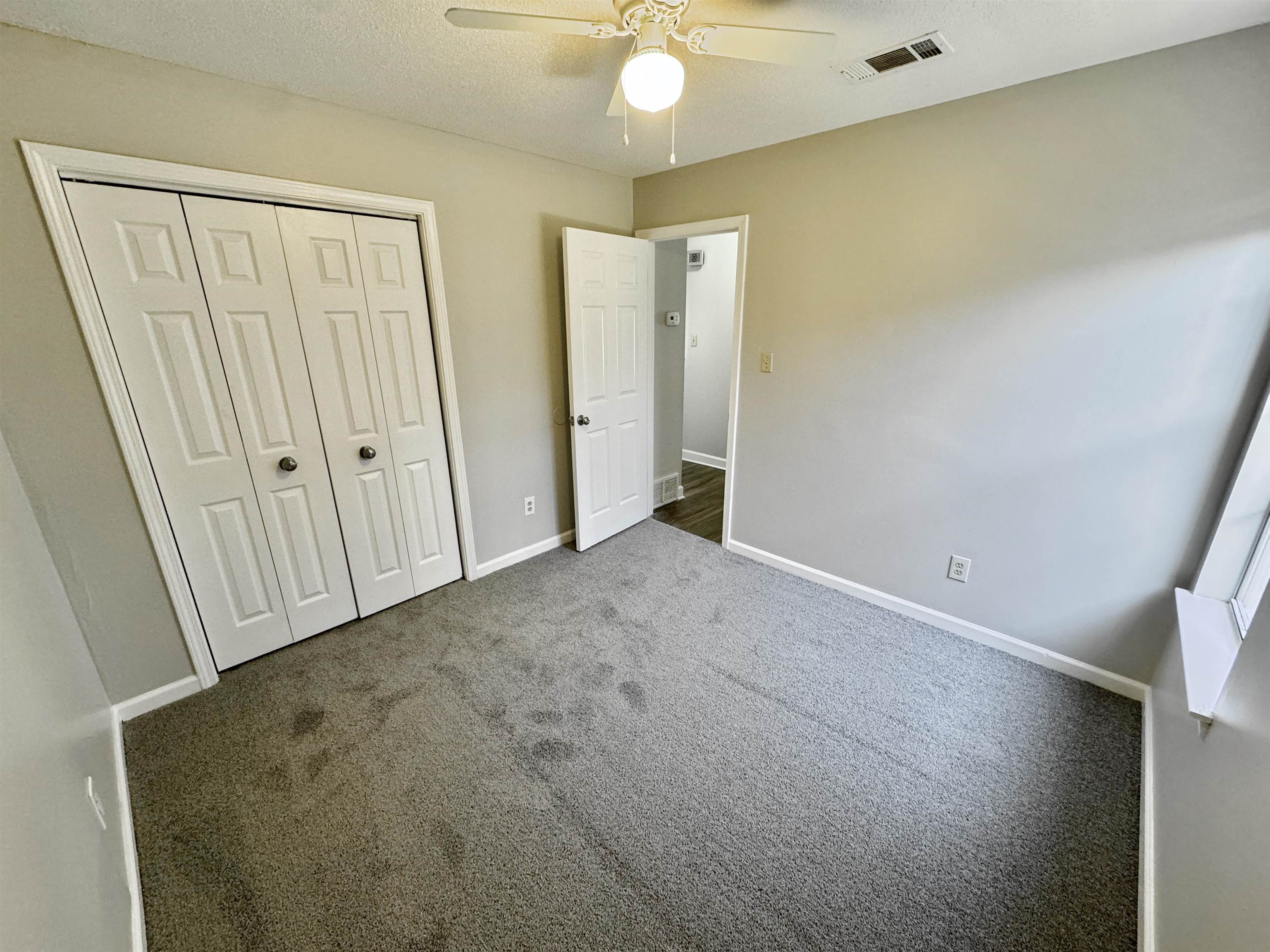 8373 Old Dexter Road Memphis, TN 38016 - Photo 19 of 26 Unfurnished bedroom featuring ceiling fan, visible vents, baseboards, a closet, and dark colored carpet