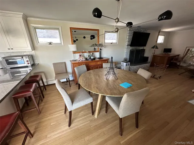 a dining room with wooden floor a glass table and chairs