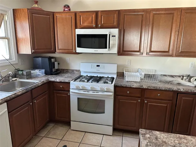 a kitchen with stainless steel appliances granite countertop a sink stove and microwave